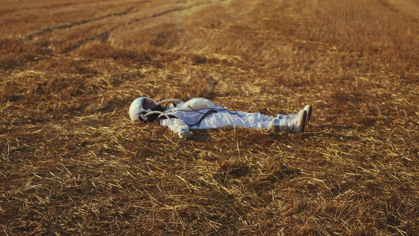 the remains of a man laying in a field of hay