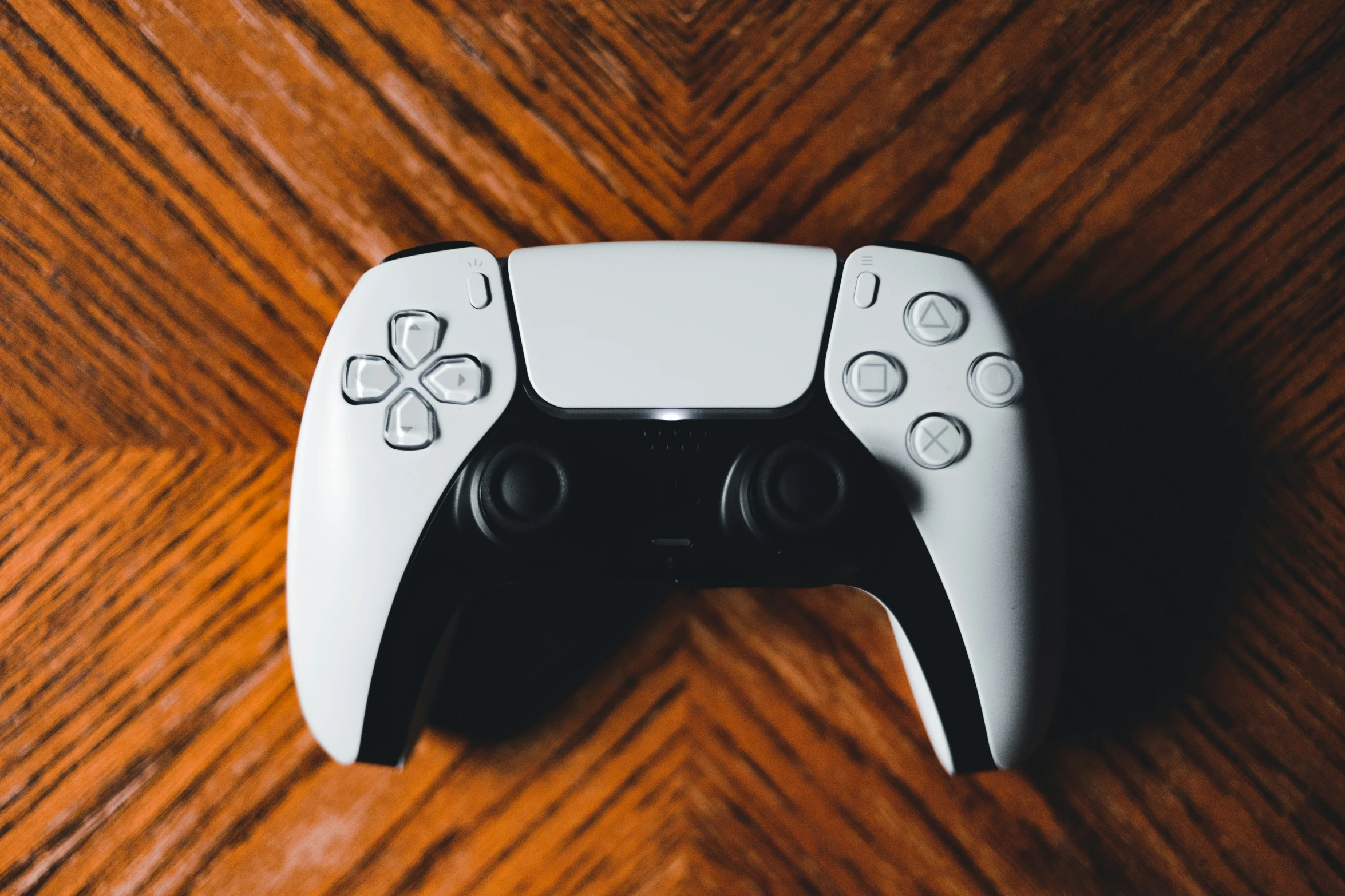 the white controller of a video game console sitting on a wooden table