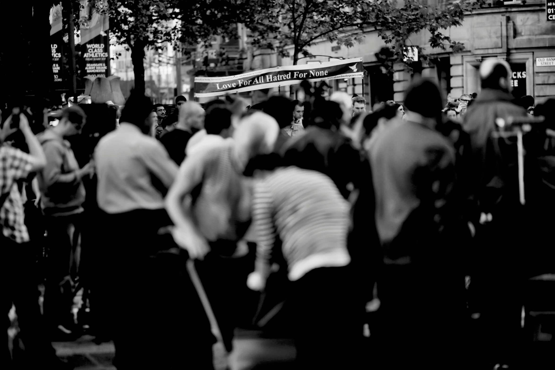 the crowd of people are waiting to cross the street