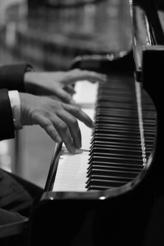 a man's hand sitting at the top of a piano