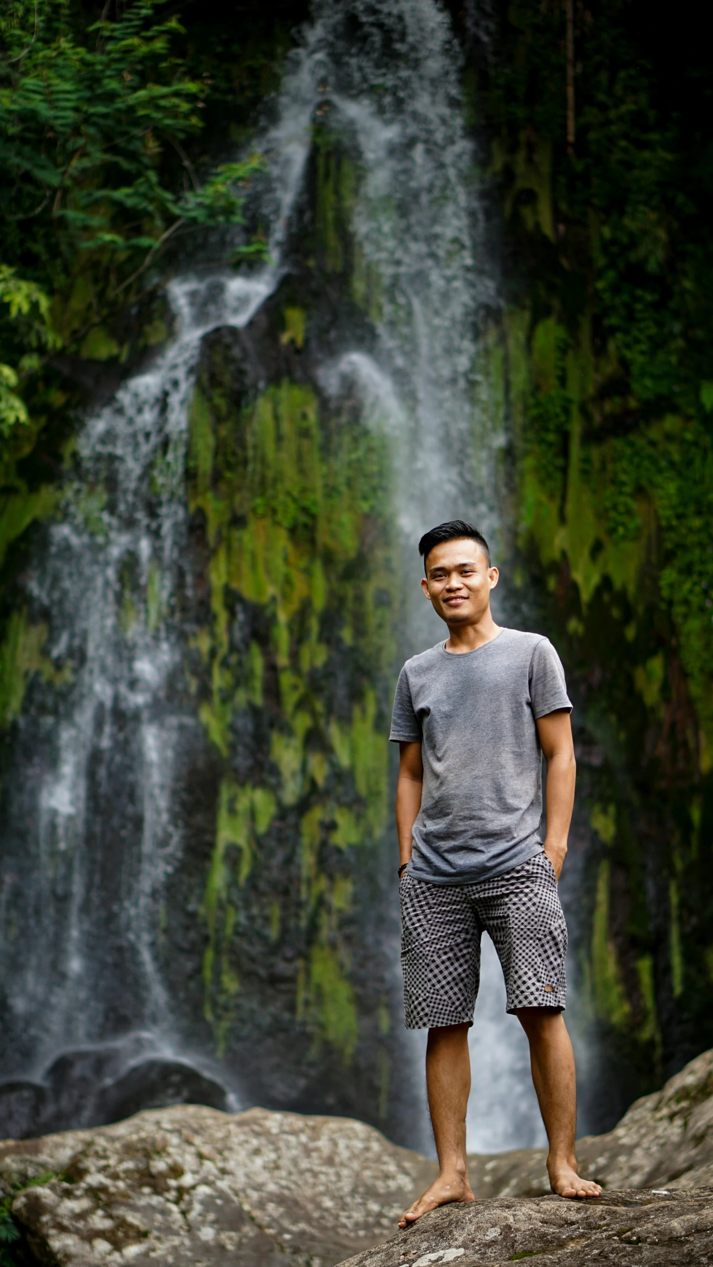 man standing in front of a water fall at night