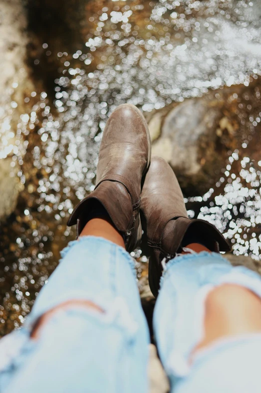 a person standing in water wearing dark boots