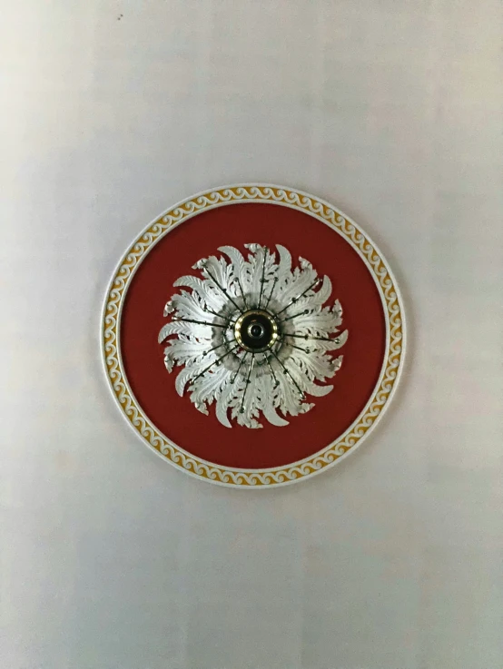 a circular clock with white and gold decoration