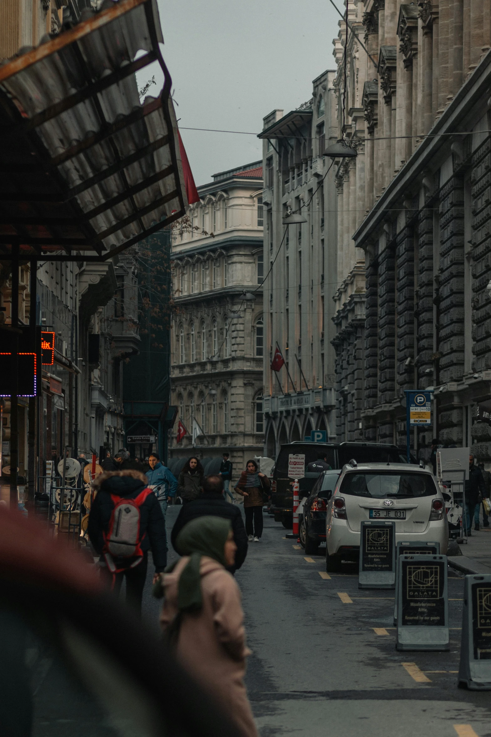 people walking down a street next to buildings