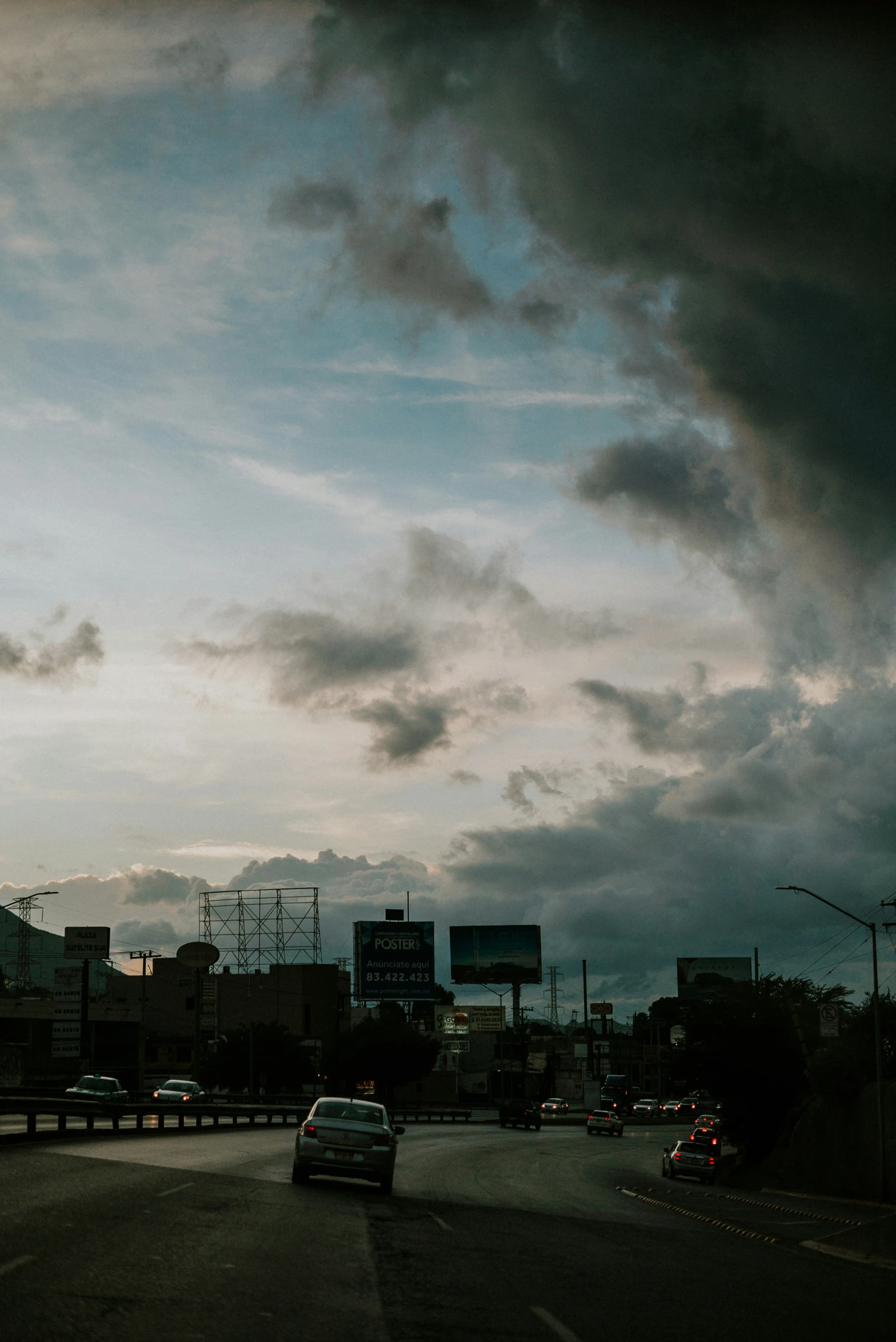 a very cloudy, dark sky is overcasting a city