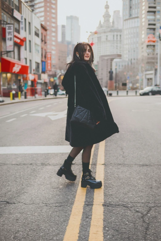 a woman walking down a road with a handbag