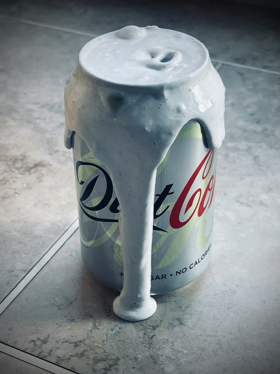 a partially eaten beverage can sitting on top of a tiled floor