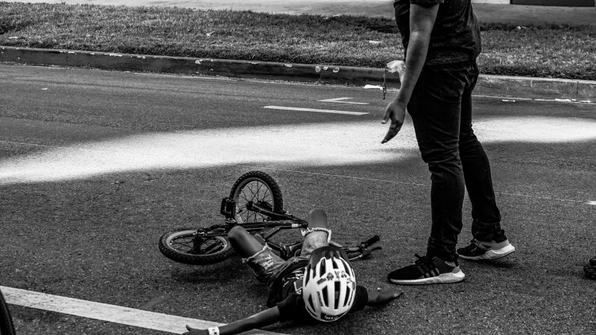 a person on their bike is laying in the street