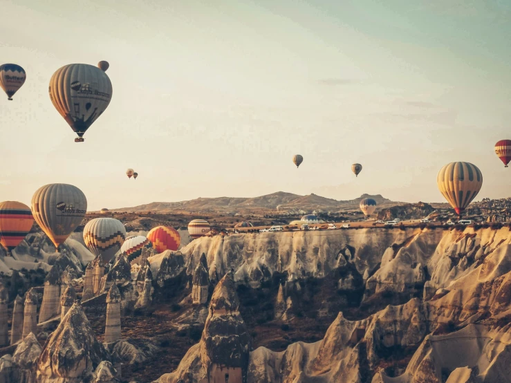  air balloons floating in the sky over mountains