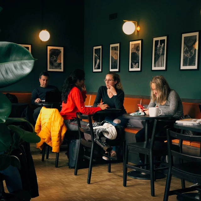 people sitting around tables at tables with computers on