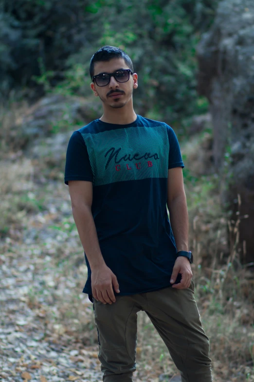 a man standing near a trail in the forest