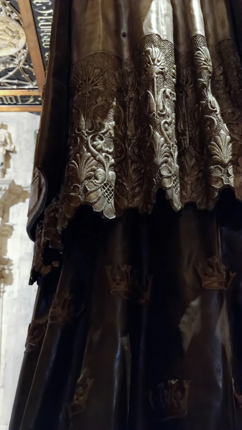 a dress with elaborate brocades is hanging in a shop