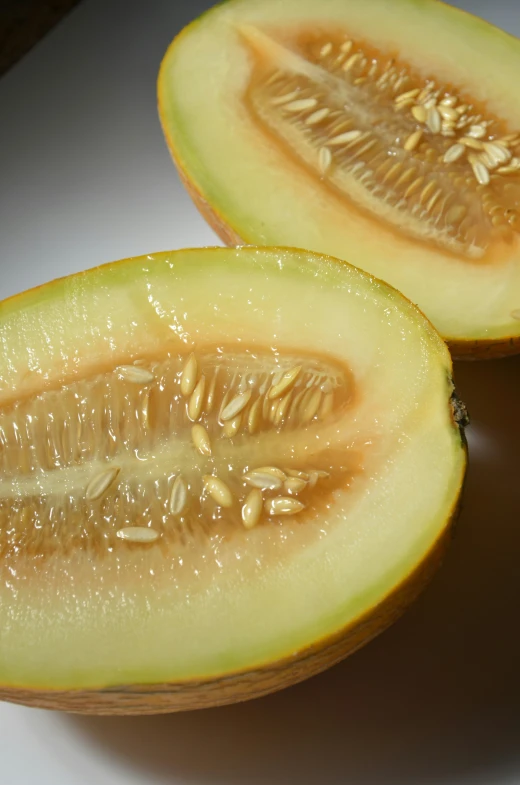 a piece of melon is cut in half and being held by a fork