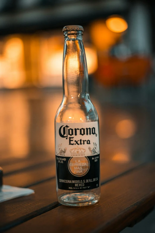 a bottle sitting on a wooden table with light coming through