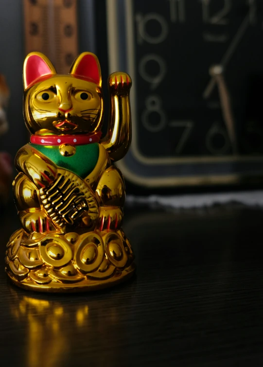 a metal gold cat figurine sitting on top of a desk