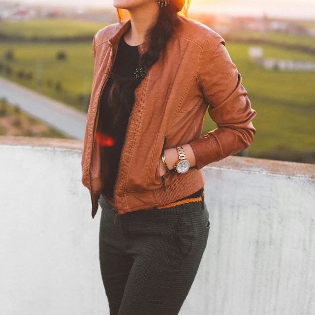 a beautiful young woman in a brown jacket