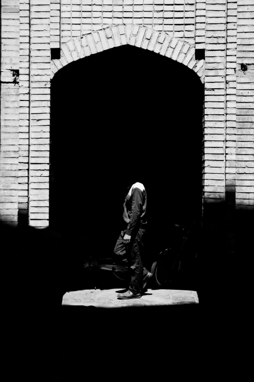 a man is walking up to a very large brick tunnel