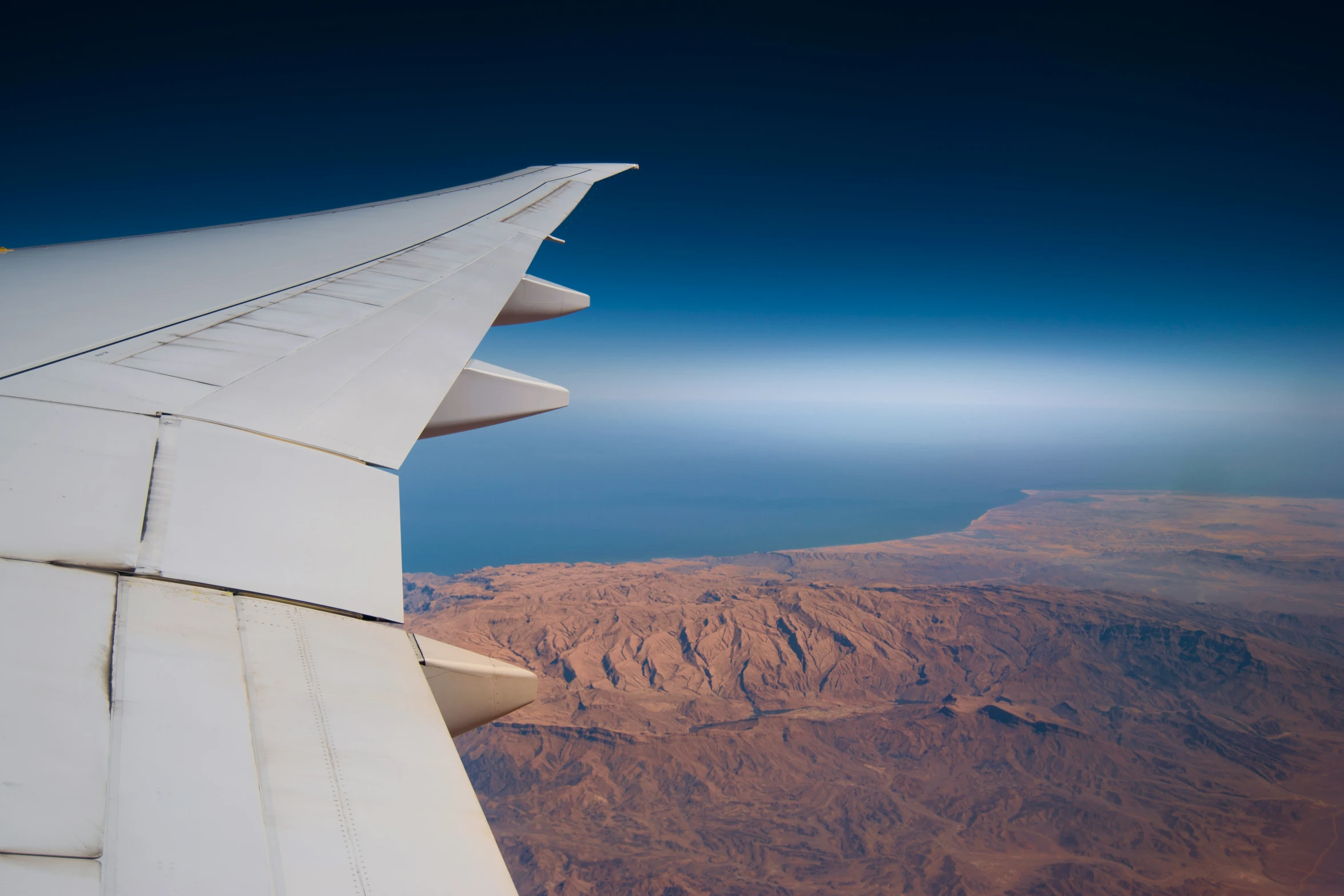 an airplane wing flying high up in the sky