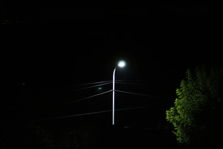 a street lamp shines bright at night