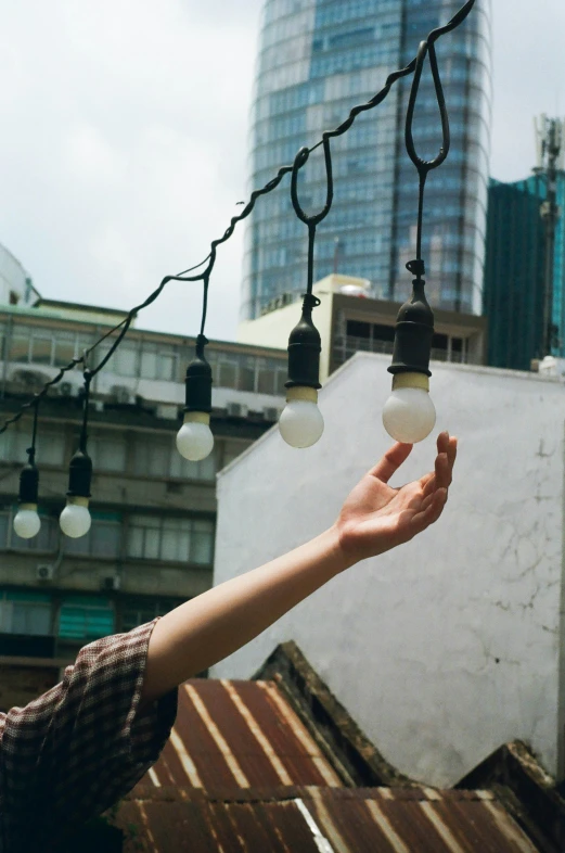 a hand holding up three small white lights