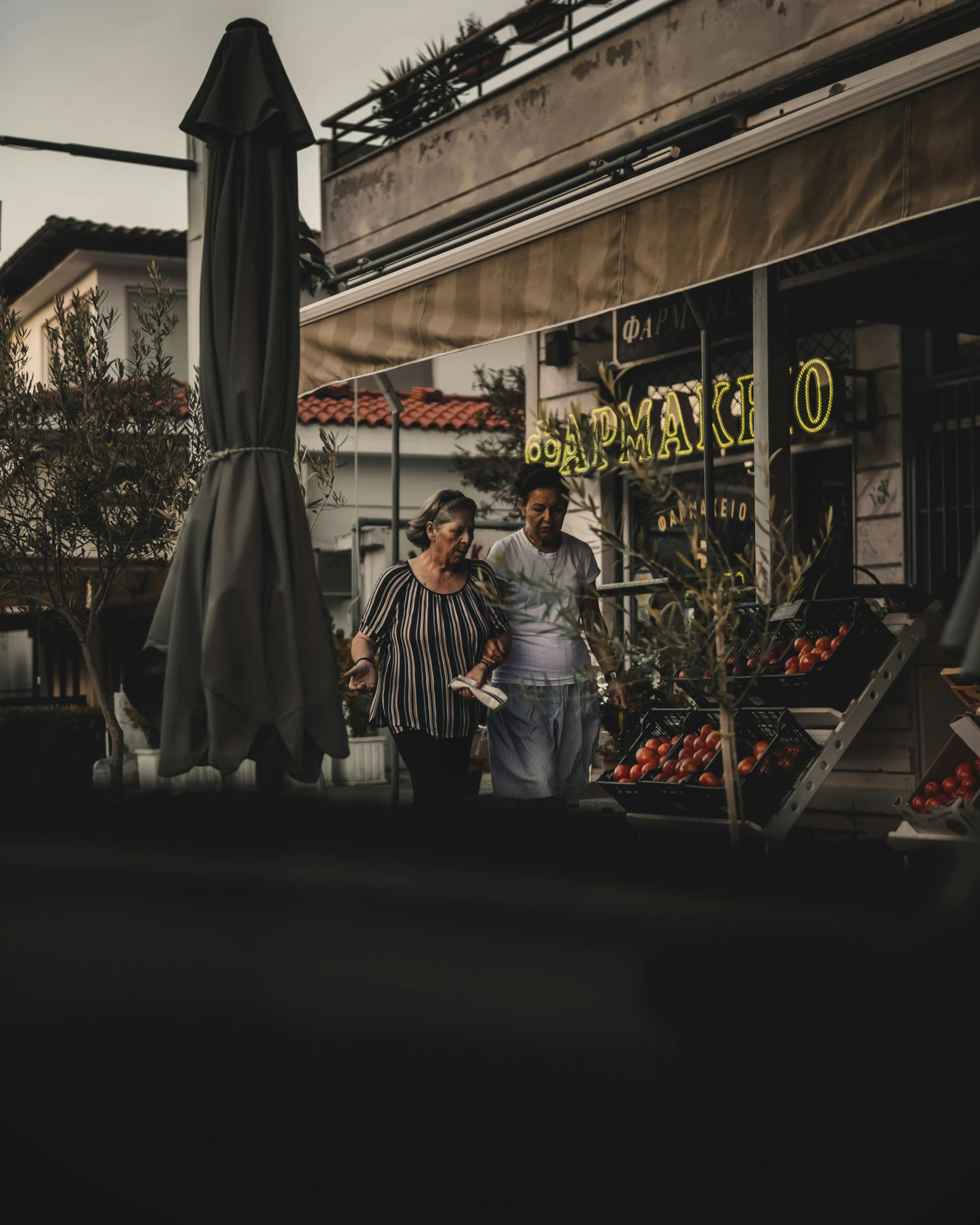 two people are outside near a fruit market