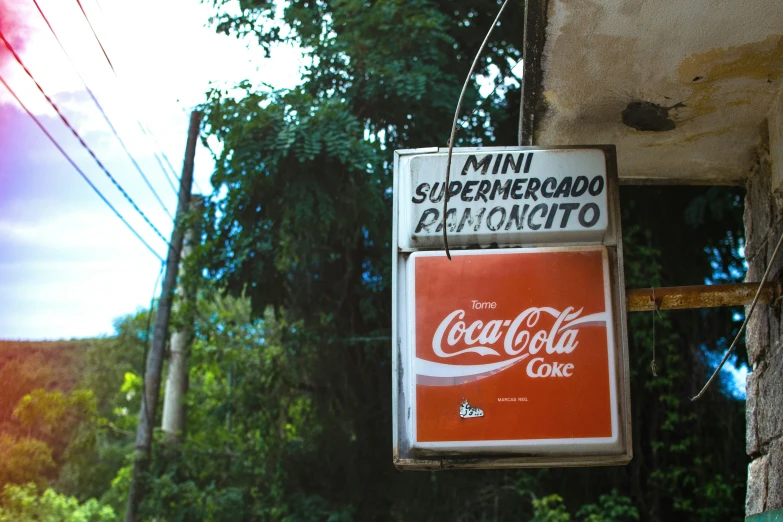 a hanging sign that is advertising a coca cola store