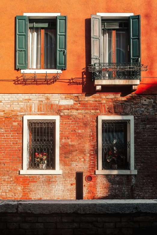 windows and balconies on red brick building in italy