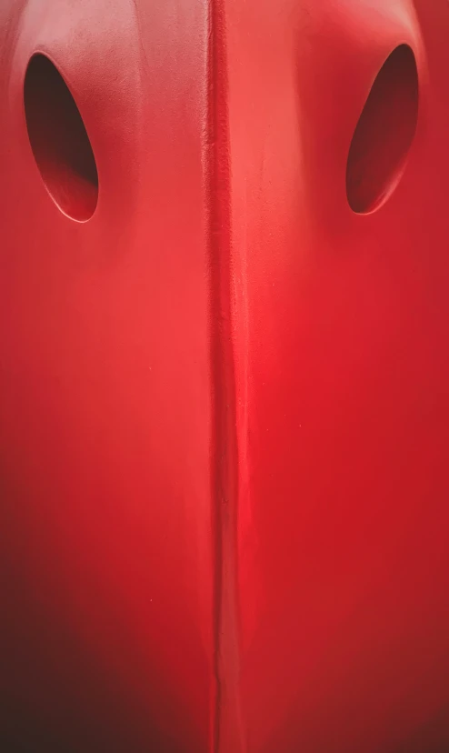 the side of a red car with holes in it