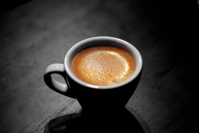 a cup of coffee on the table with dark background