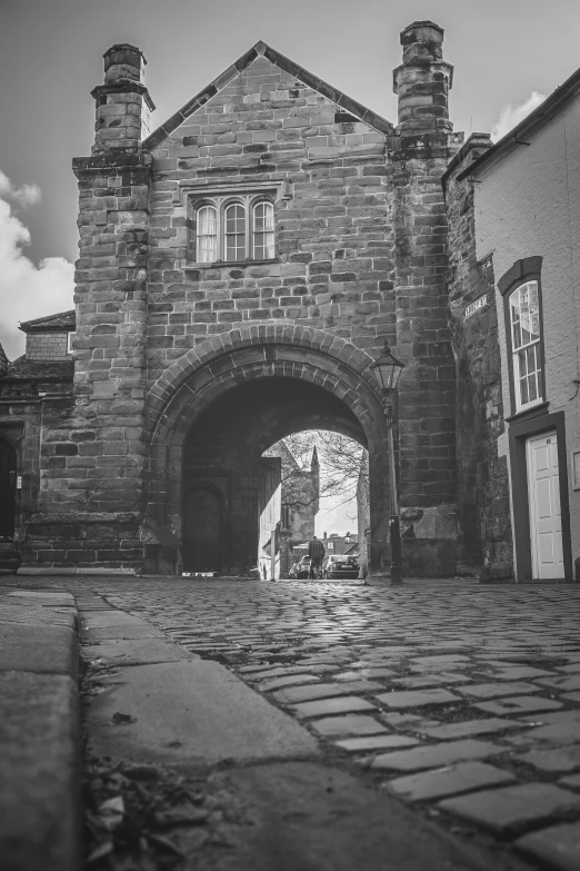 a brick gate in front of an old stone building