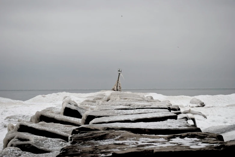 a rock outcropping covered in ice is shown on a dark grey day