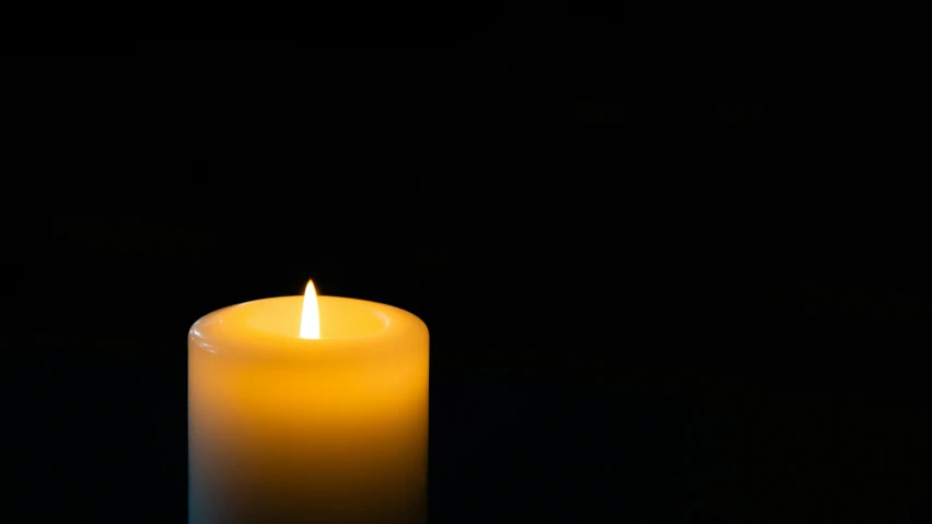 a lit candle is glowing in the dark