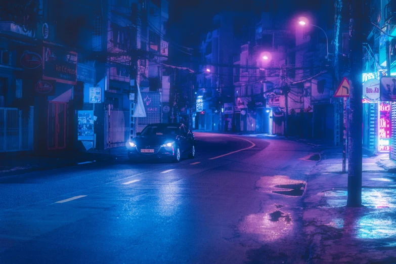 an old car that is driving down the street at night