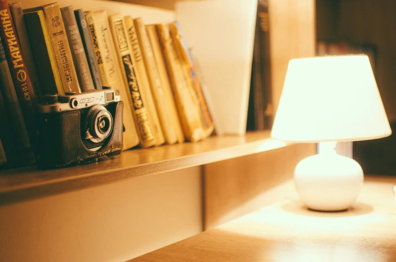 a lamp is on near a book shelf with books