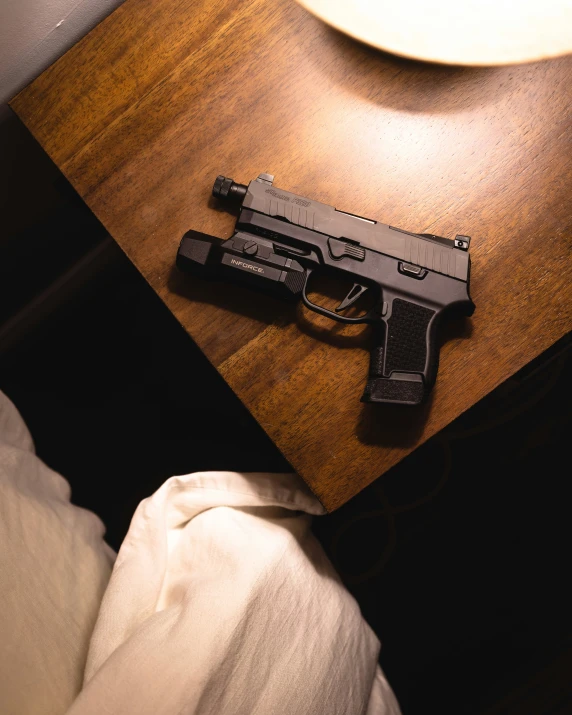 a gun is on a table next to the bed