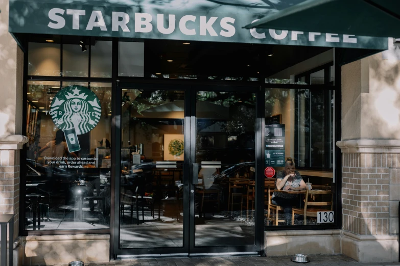 a starbucks storefront displays a sign reading starbucks's coffee