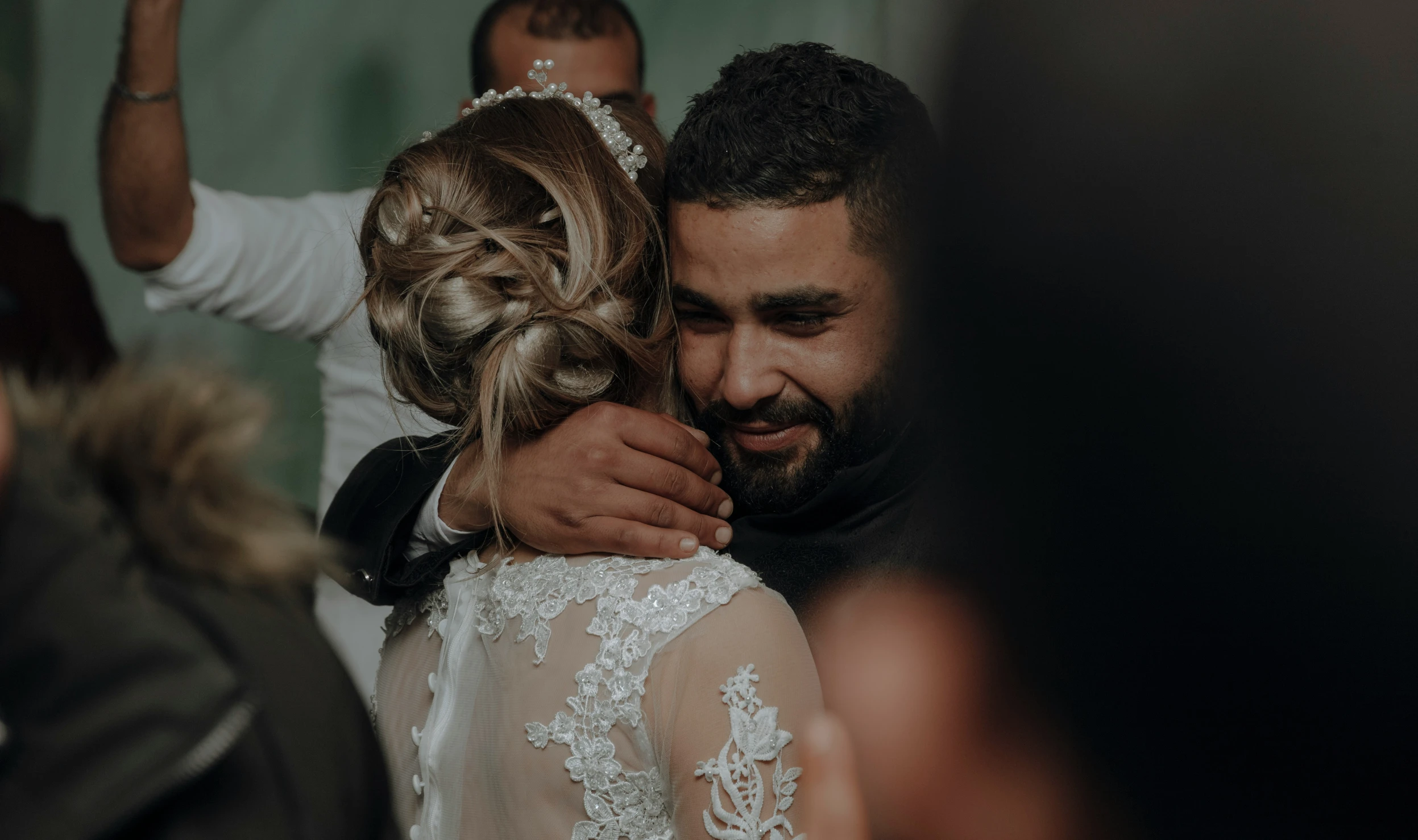 a bride hugs her groom on the forehead as he looks at him