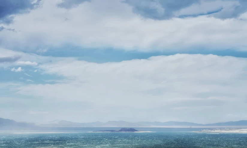 two people ride horses down the road in the middle of the ocean