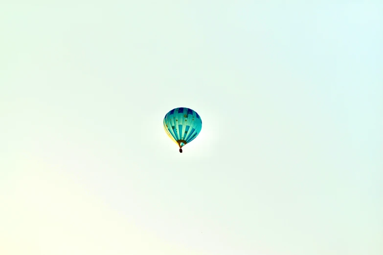 a green  air balloon is seen in the sky