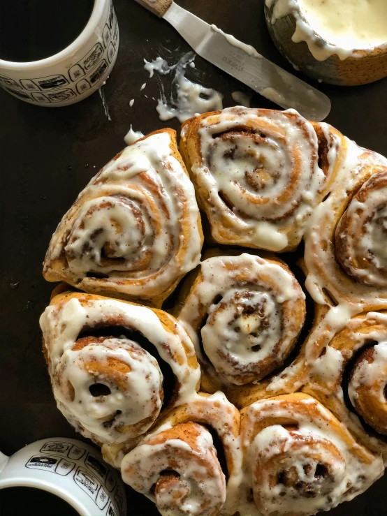 a cake plate with cinnamon roll rolls covered in icing