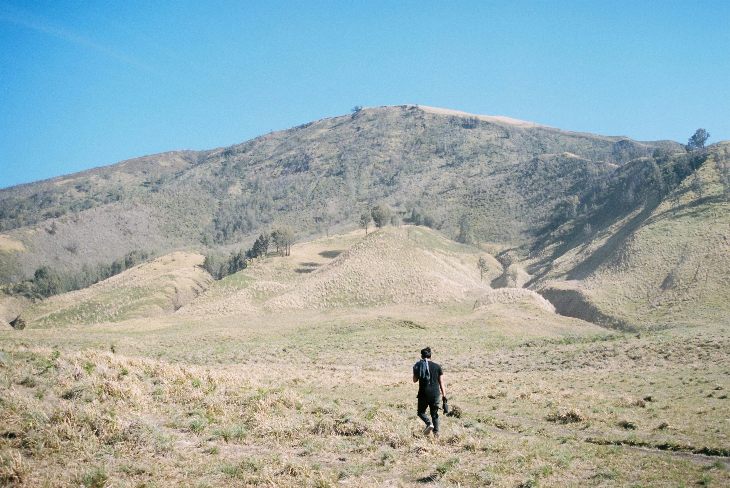 a man with a black suit on a mountain