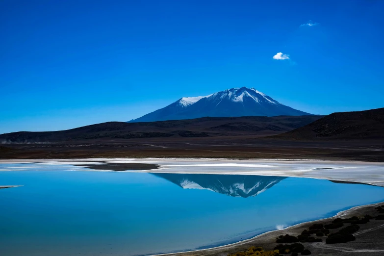 there is a mountain rising behind some water