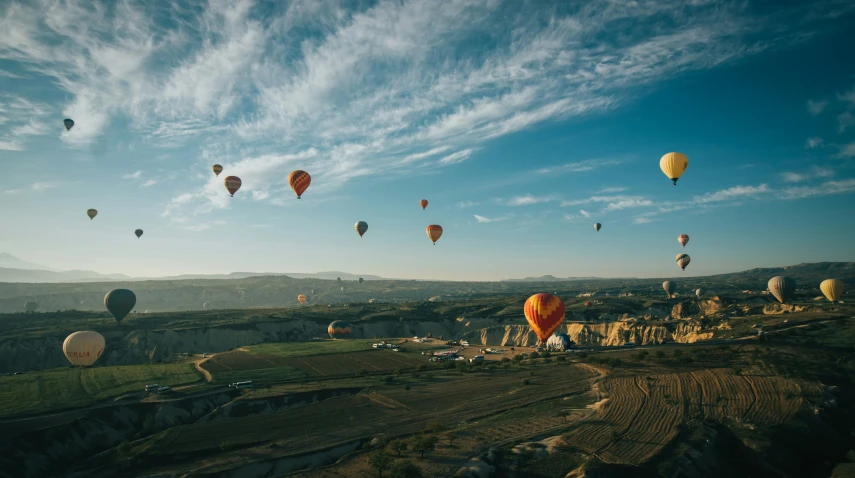 many  air balloons in the sky above the mountain