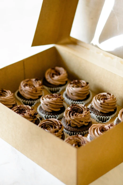 there are twelve chocolate cupcakes sitting in the box