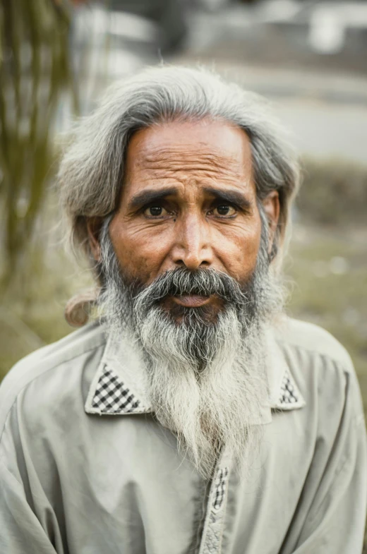 a man with grey hair and beard standing in the street