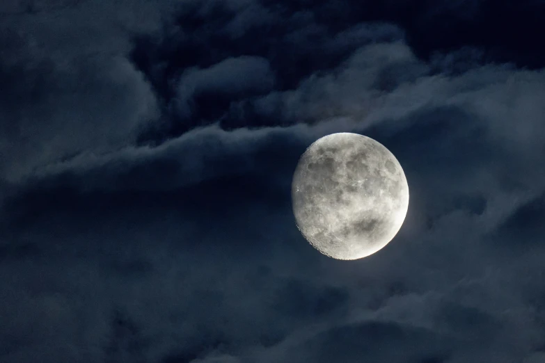 the moon is bright on a cloudy sky