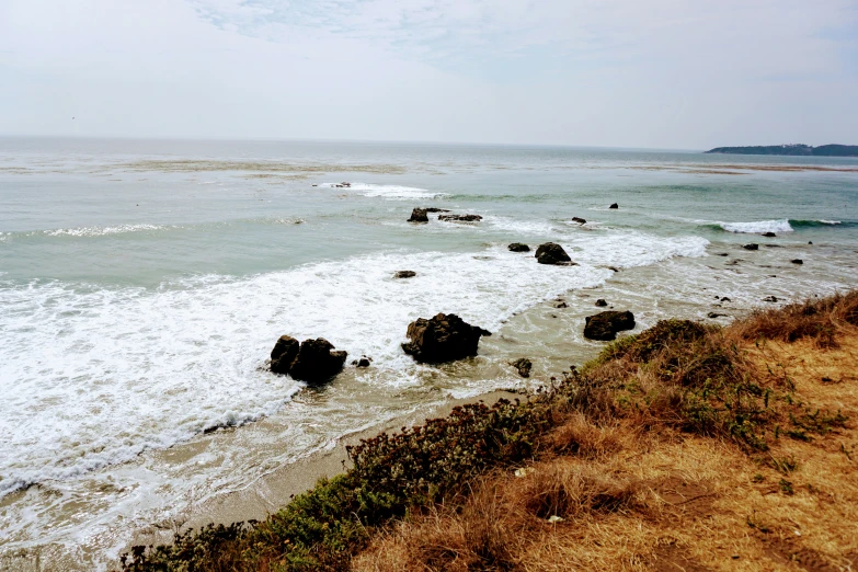 a sandy beach with water on the edge