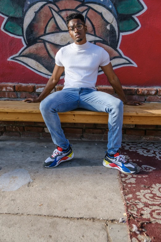 a man sitting on a bench in front of a mural