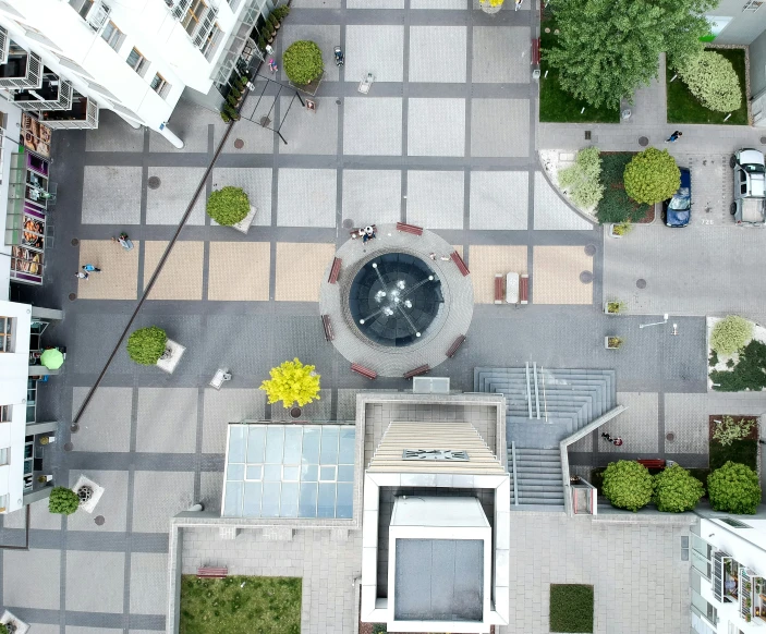 an aerial view of a plaza with a fountain and seating area