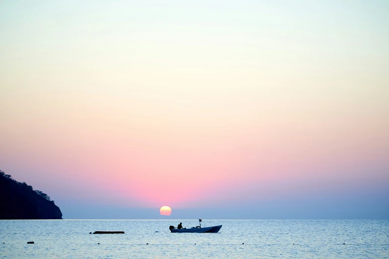 a boat is out in the open water during a sunset